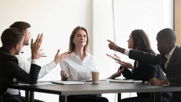 while stressed colleagues screaming to young businesswoman she meditating - yoga meditating business group of people imagens e fotografias de stock