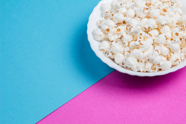 istock White bowl of popcorn on a blue and purple background 1233132817