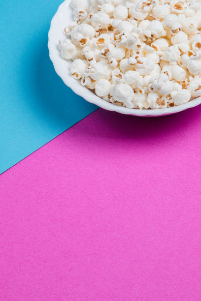 istock White bowl of popcorn on a blue and purple background 1233134433