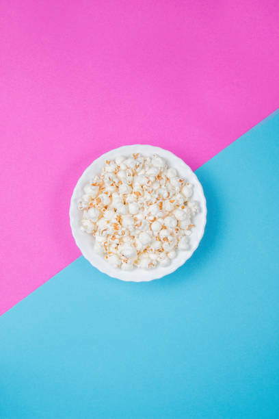 istock White bowl of popcorn on a blue and purple background 1233134445