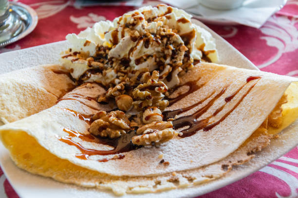 Pancakes with whipped cream, walnuts and maple syrup in Italy.