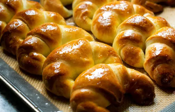 Photo of Argentine croissants, medialunas de Manteca over silicon pastry mat background