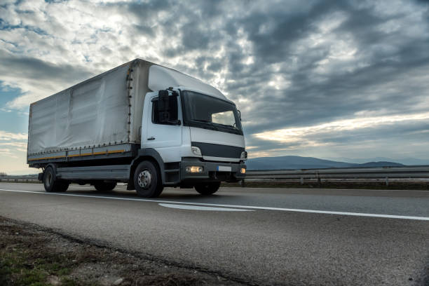 istock White transportation semi trailer truck on a highway at sunset 1233316111