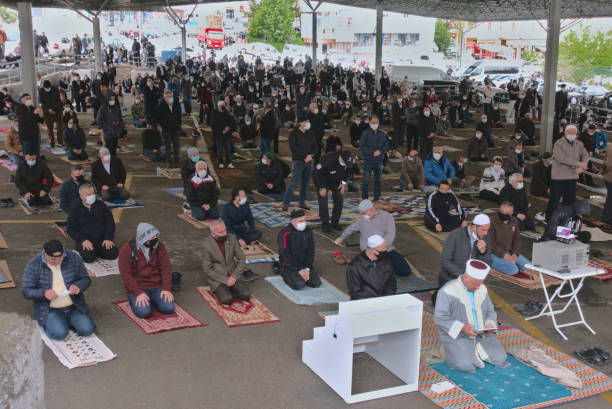 Distanced Muslim men sitting in jumah prayer after 3 months quarantine in Turkey stock photo