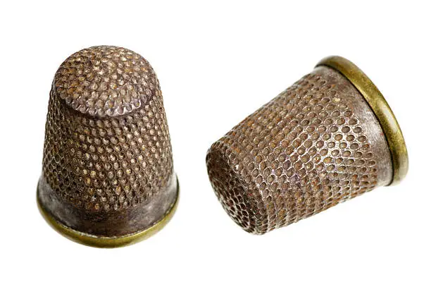 Old steel and brass thimbles isolated on a white background.