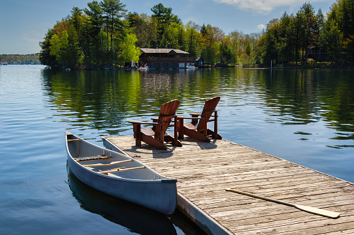 Couple canoeing on a lake of the Laurentians,  Quebec, during a sunrise of summer.