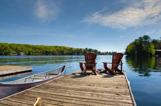 Muskoka chairs sitting on a wooden dock stock photo