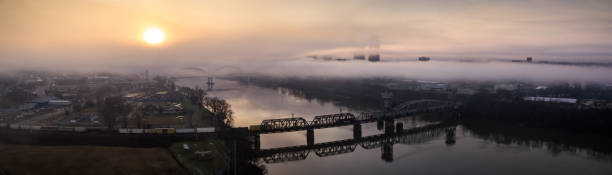 tren de carga cruzando el río arkansas en little rock - panorama aéreo - freight train railroad track train rock fotografías e imágenes de stock