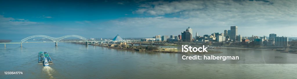 Drone Panorama of the Hernando de Soto Bridge, Mud Island and Downtown Memphis Drone shot of a barge on the Mississippi, approaching the Hernando de Soto Bridge connecting Memphis, Tennessee and Arkansas. Memphis - Tennessee Stock Photo