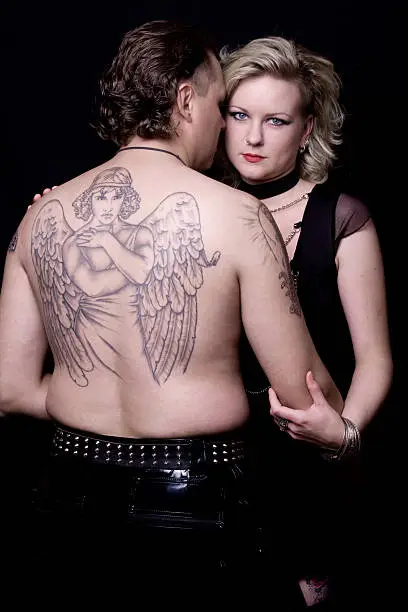 Gothic couple with big angel tatoo on his back
