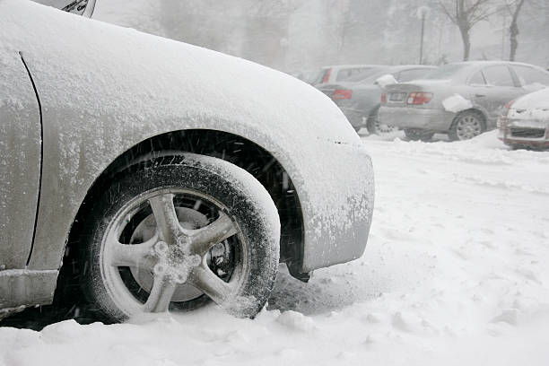 close up shot of frozen car tire during snow storm.
