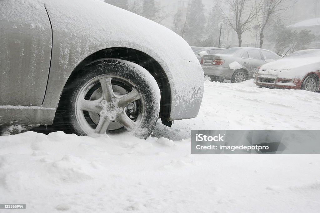 frozen tire close up shot of frozen car tire in parking lot. Blizzard Stock Photo