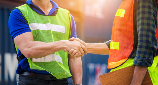 istock Close up of engineer and foreman worker handshake with blurred construction site, Success and Teamwork concept 1233673205