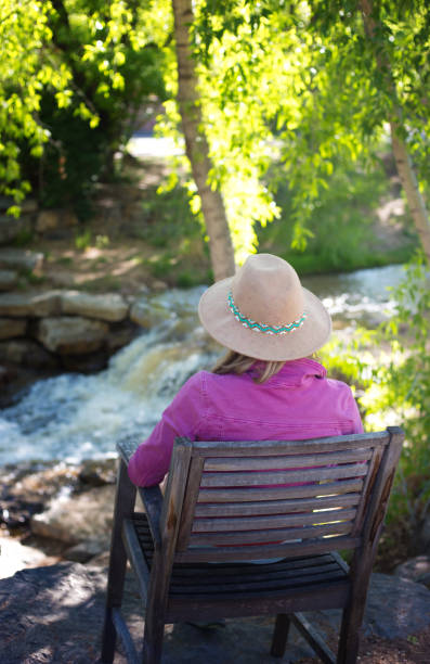 istock Pensive Woman Sits Near Waterfall/Stream 1233708058