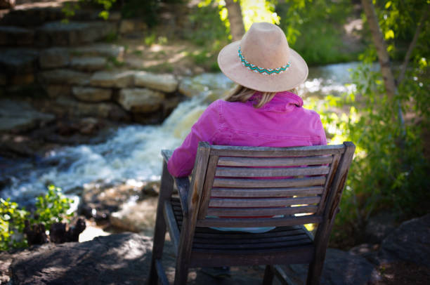 istock Pensive Woman Sits Near Waterfall/Stream 1233712094