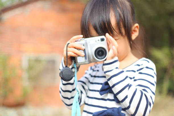 istock a Asian girl taking photos with a digital camera. 1233737350