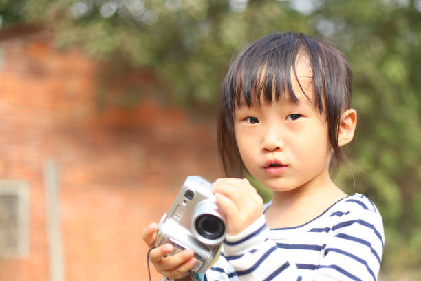 istock a Asian girl taking photos with a digital camera. 1233744392
