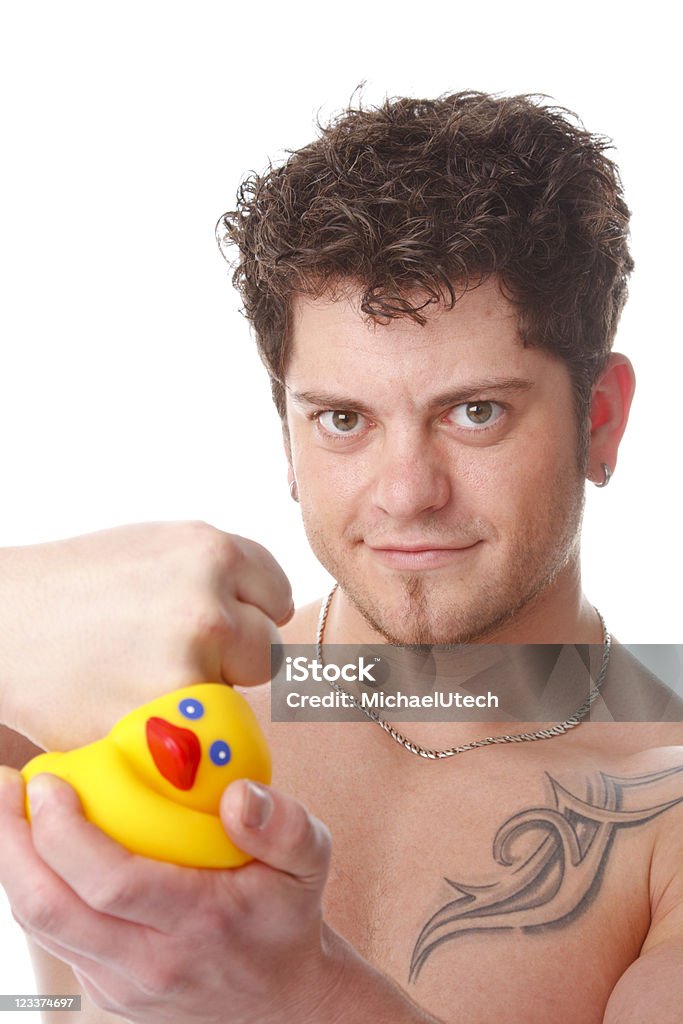 Strong Man Crushing A Rubber Duck A muscular man showing his strength by crushing a rubber duck. 20-29 Years Stock Photo