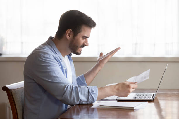 istock Handsome guy annoyed by paper dismissal notice, document mistake. 1233750970