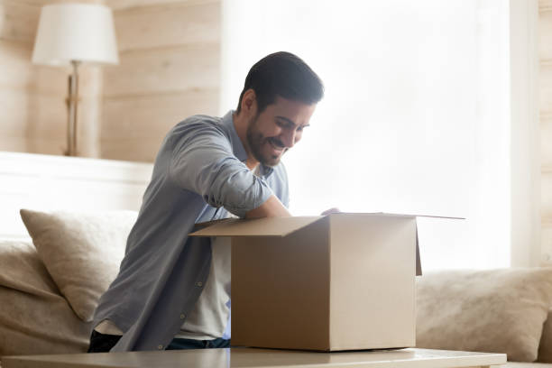 istock Happy male client satisfied with fast delivery service, unboxing purchase. 1233750981