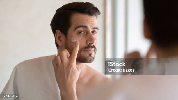 Millennial Stattlichen Mann Auftragen Feuchtigkeitsbefeuchtend Nach Rasiercreme Stockfoto und mehr Bilder von Männer