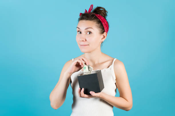 istock the girl pulls out crumpled dollars with an anticipation of 1233752565
