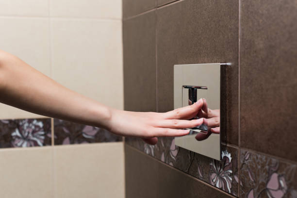 istock Girl's hand presses a large flush button in the toilet 1233752571