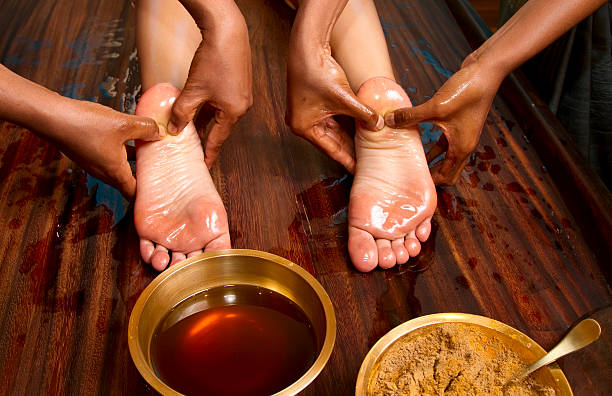 traditional indian ayurvedic oil foot massage indian doctors doing traditional ayurvedic oil foot massage ayurveda stock pictures, royalty-free photos & images