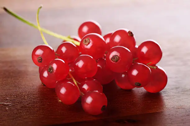 Freshly picked redcurrants placed on wooden serving board