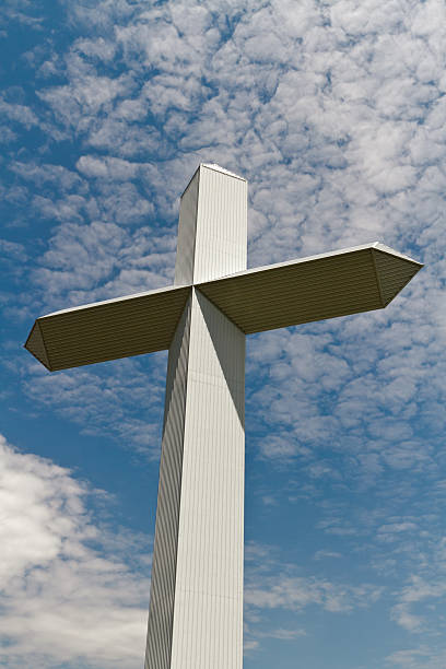 Christian Cross with blue sky and clouds stock photo