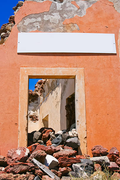 Part of architecture in abandoned house with blank billboard in beautiful village of Oia in Santorini, Greece