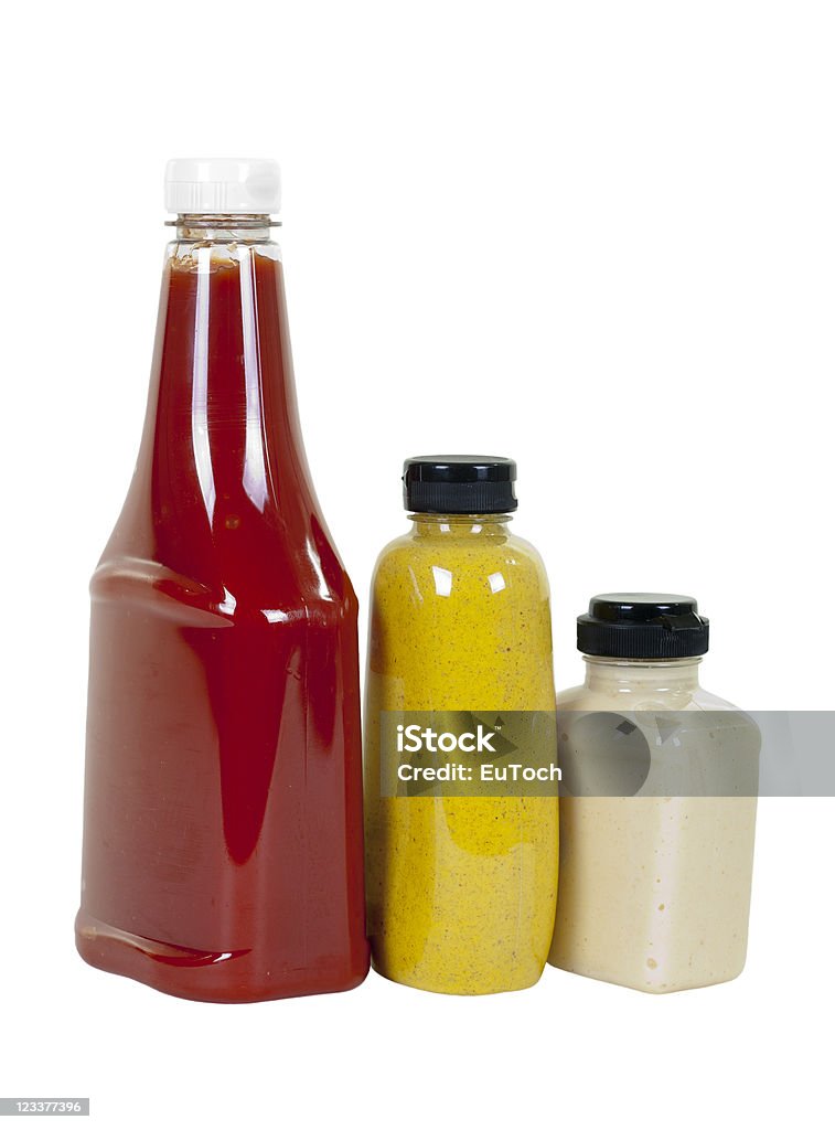 Ketchup, Mustard and Horseradish in Bottles; Angle View Tomato ketchup, spicy brown mustard and creamy horseradish in bottles, angle view; isolated on white background Bottle Stock Photo