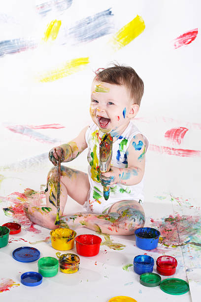 istock Young child covered in colorful paint and making mess 123380492