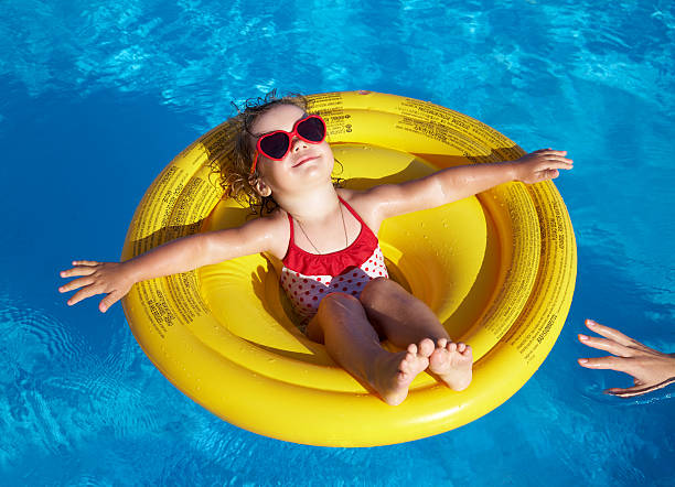 Little girl swims in  pool stock photo