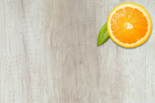 Orange slice in a circle on wooden background. Focus on orange