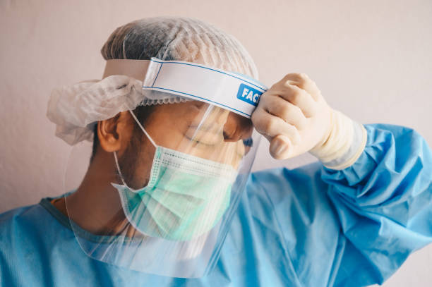 istock Doctor having headache and tired from work while wearing PPE suit for protect coronavirus disease. 1233966684