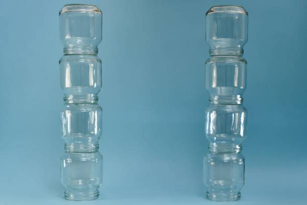 istock Two vertical parallel rows of glass jars on a blue background. 1233969720