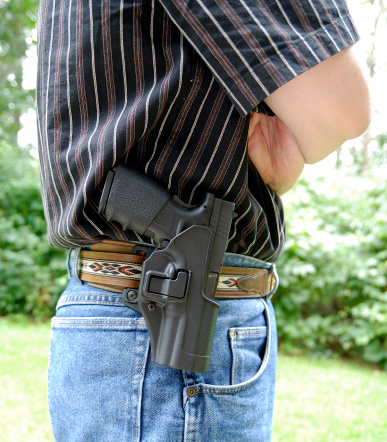 Vertical of a belt mounted riged holster holding a semi automatic pistol.