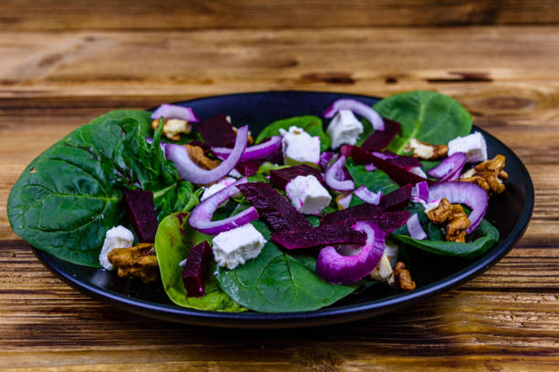 istock Salad with spinach leaves, feta cheese, beetroot, walnuts and onion on a black plate 1234196267