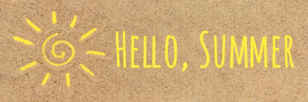 Photo of Hello summer text Sun sign drawn on sand. Creative top view Copy space Banner