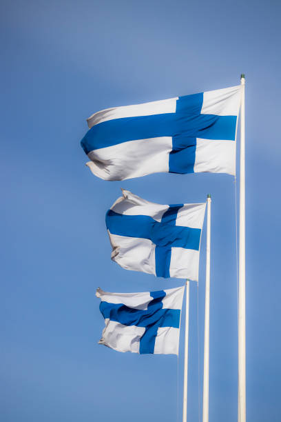 istock Three finnish national flags on the wind against the blue sky 1234201594