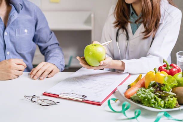Nutritionist giving consultation to patient with healthy fruit and vegetable, Right nutrition and diet concept Nutritionist giving consultation to patient with healthy fruit and vegetable, Right nutrition and diet concept nutritionist stock pictures, royalty-free photos & images