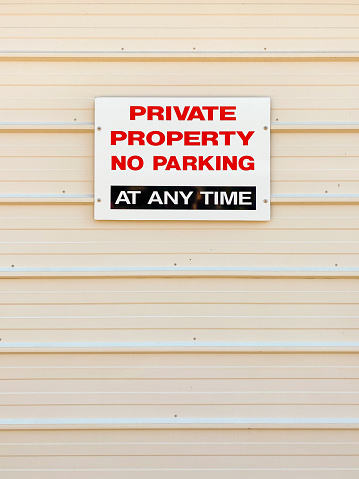 Vertical close up of Private Property No Parking sign on garage door