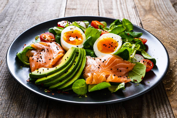 istock Smoked salmon with boiled eggs, avocado and vegetables on wooden table 1234302006