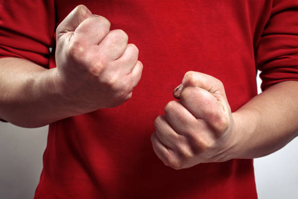 the man's clenched fists. aggression, domestic or family violence, family problems