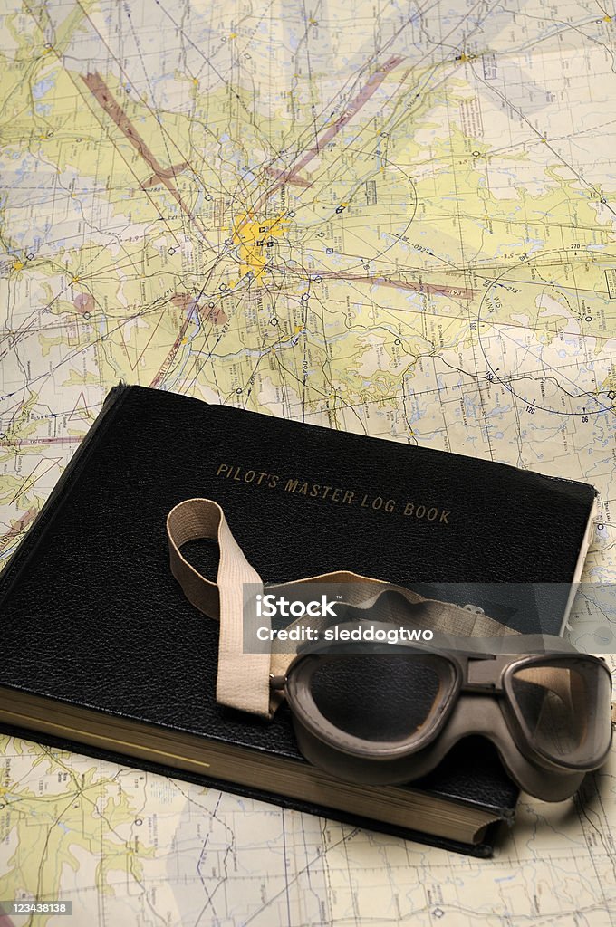 Vintage Goggles V Vertical of vintage aviation goggles on a pilot logbook with an old avition chart in the background. Airplane Stock Photo