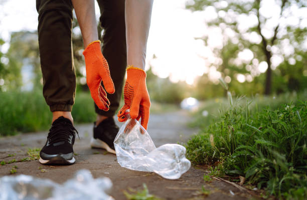 istock Men hand collects plastic trash for cleaning in the park. 1234451100