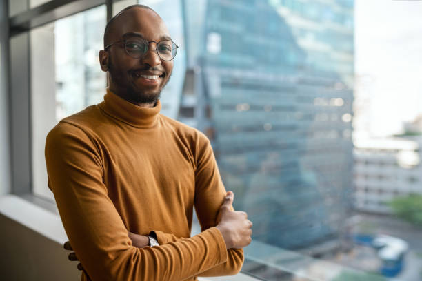 istock Smiling African businessman standing by office windows overlooking city 1234459376