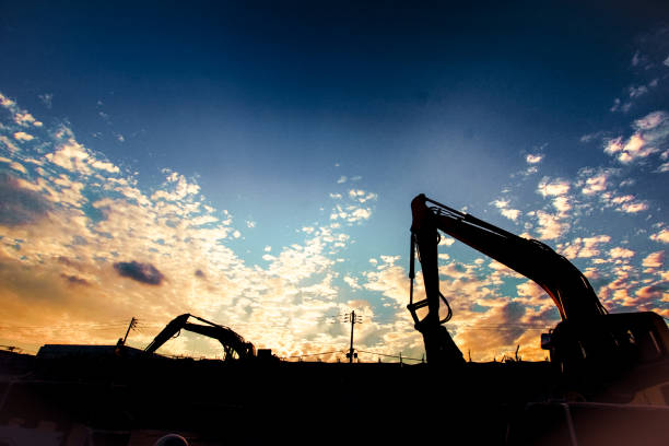 Excavator loads the soil into the dump truck. Development of the foundation for building a house. Earthworks at the construction site. Construction of building and residential house.