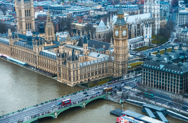 Aerial view overlooking London and Big Ben clock tower Aerial view of the city of London, overlooking multiple old buildings. In the middle the Big Ben clock tower. To the left the river of thames. thames river photos stock pictures, royalty-free photos & images